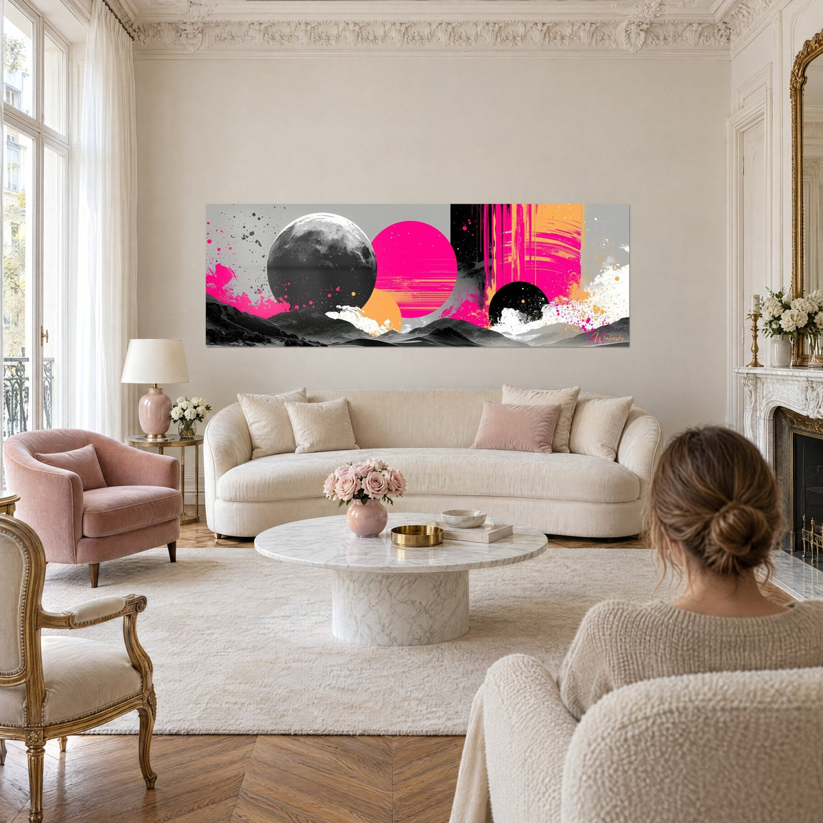 Tableau planète lunaire grise cernée de rose fluo, éclaboussures blanches, au-dessus d'un canapé dans un salon lumineux