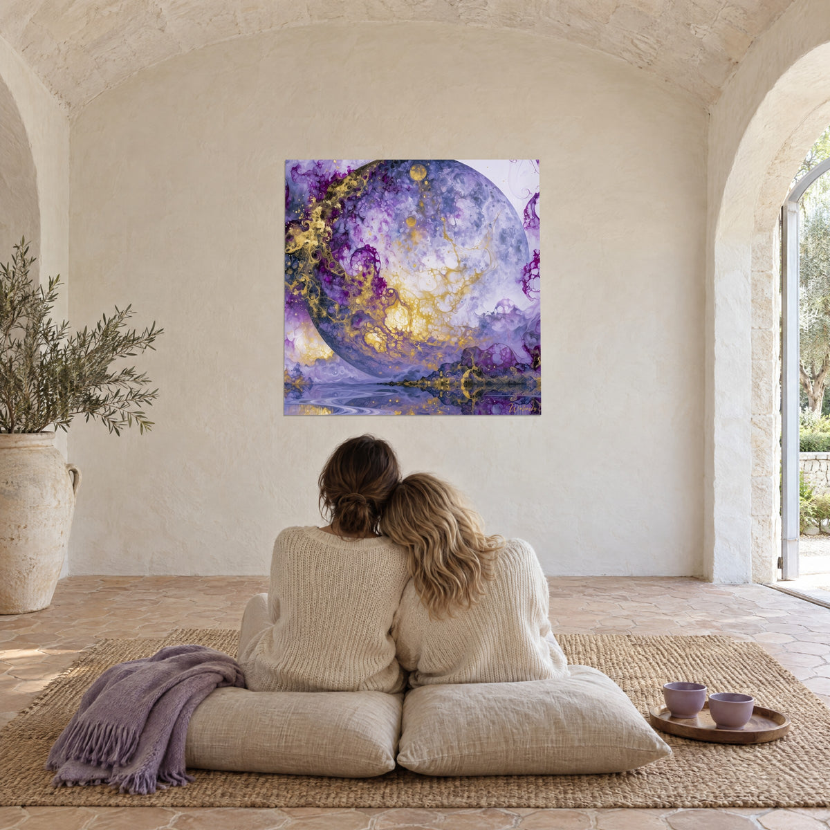 Tableau lune fluide violette et or reflétée dans l'eau, sur le mur d'une pièce voûtée, deux personnes assises sur des coussins