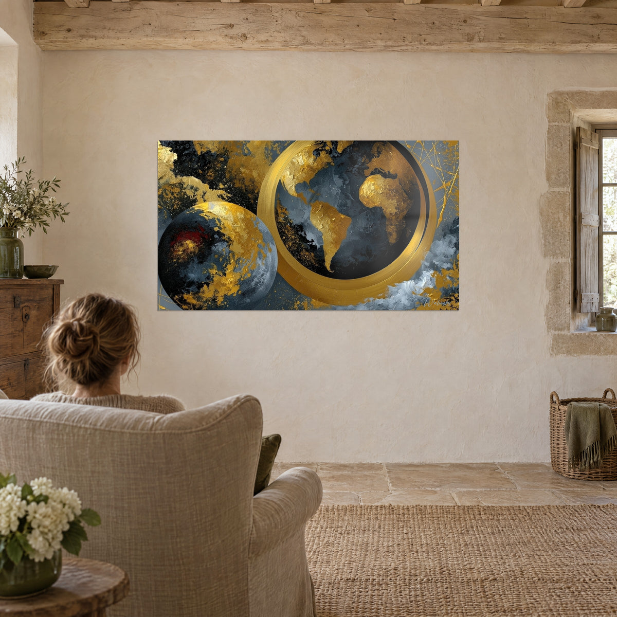Tableau monde en or ciselé, deux planètes noires et argentées, anneau scintillant, mur beige d'un salon en pierre
