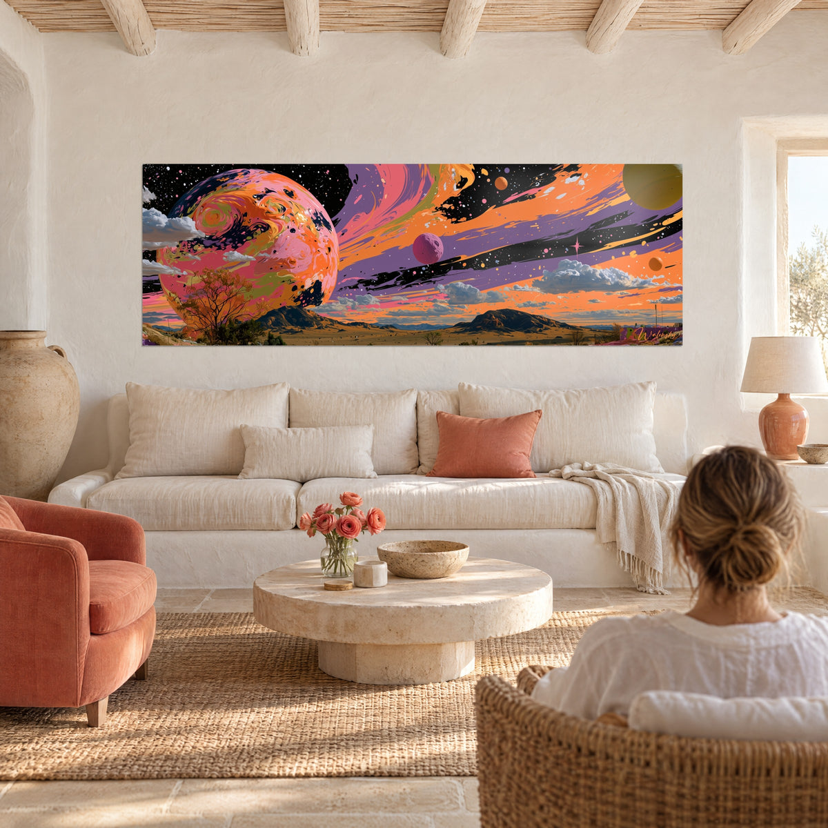 Tableau planète marbrée rose et orange surplombant un désert, ciel violet strié, femme de dos, au-dessus d'un canapé dans un salon lumineux