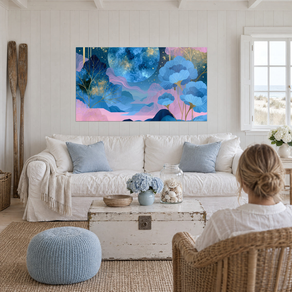 Tableau planète marbrée de bleu et d'or flottant sur un ciel étoilé, fleurs en éventail roses au-dessus d'un canapé dans un salon lumineux