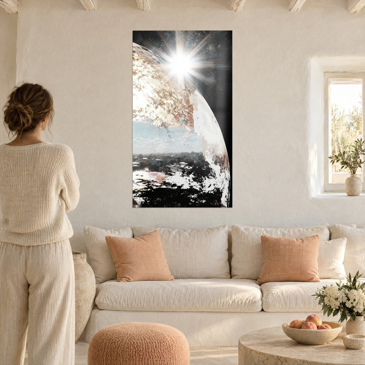Tableau planète nacrée striée d'or, soleil rayonnant sur fond d'étoiles, femme de dos au-dessus d'un canapé dans un salon lumineux