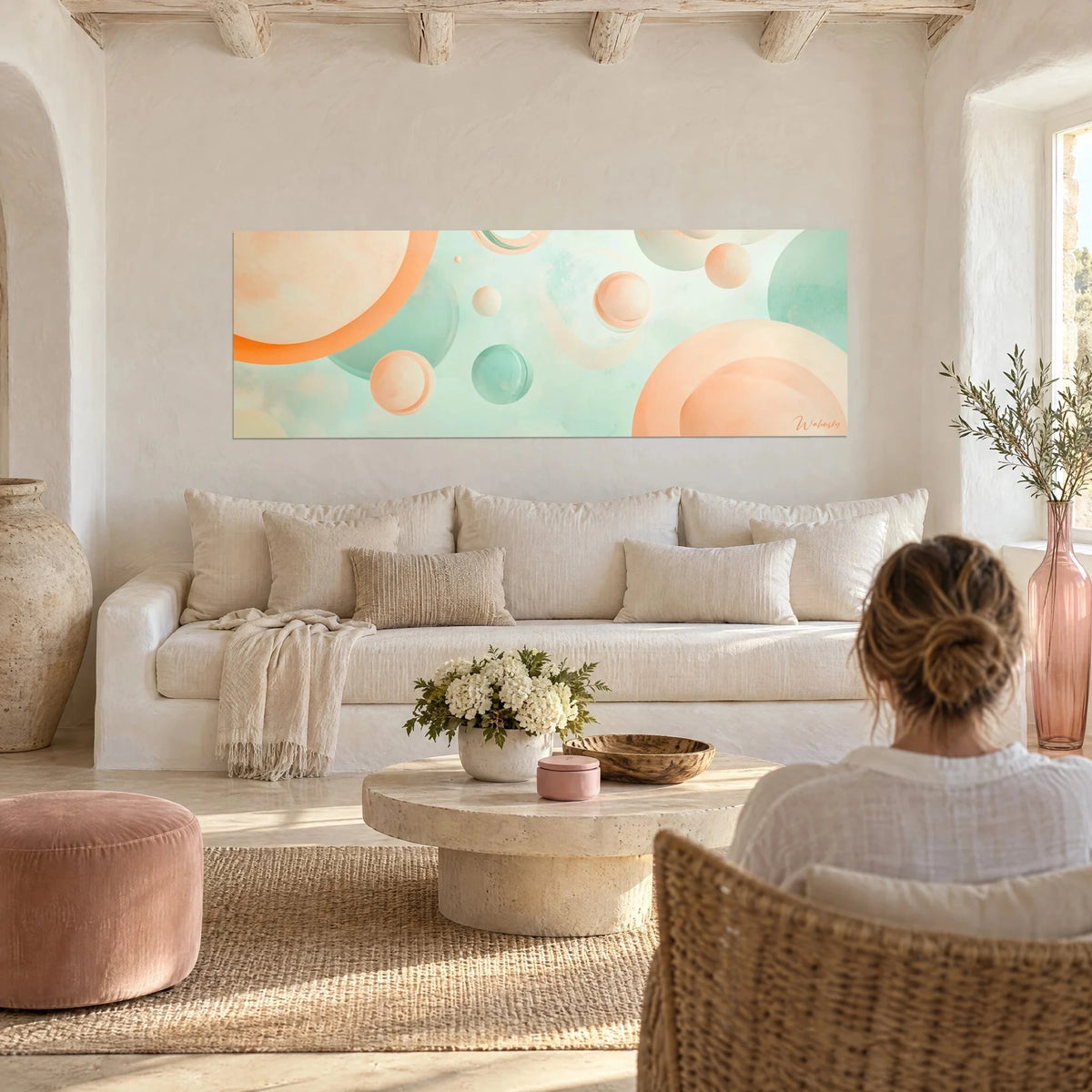 Gemälde mit pastellfarbenen Kugeln in Pfirsich und Minzgrün, die auf opalinem Hintergrund schweben, über einem Sofa in einem hellen Wohnzimmer