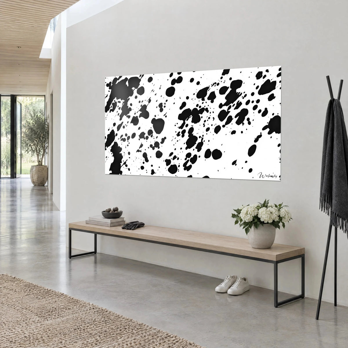 Tableau taches de vache noir et blanc en larges nappes et fins points, vue de biais près d'un banc en bois clair et chêne