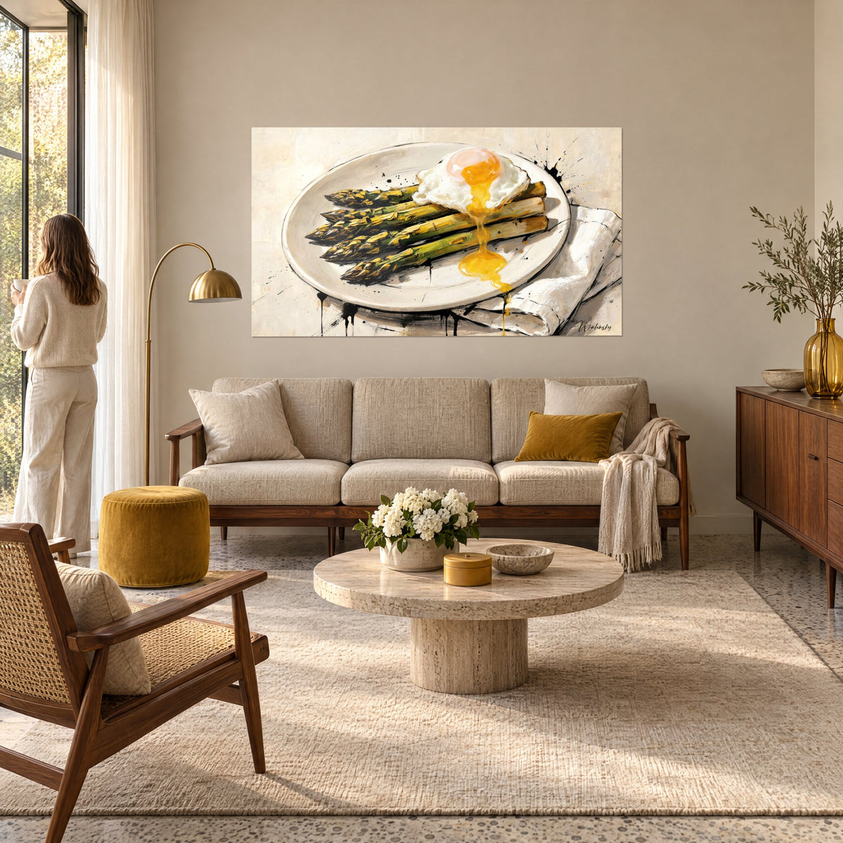 Quadro asparagi verdi dorati su piatto avorio, tuorlo d'uovo che cola; donna di spalle, sopra un divano in un soggiorno luminoso