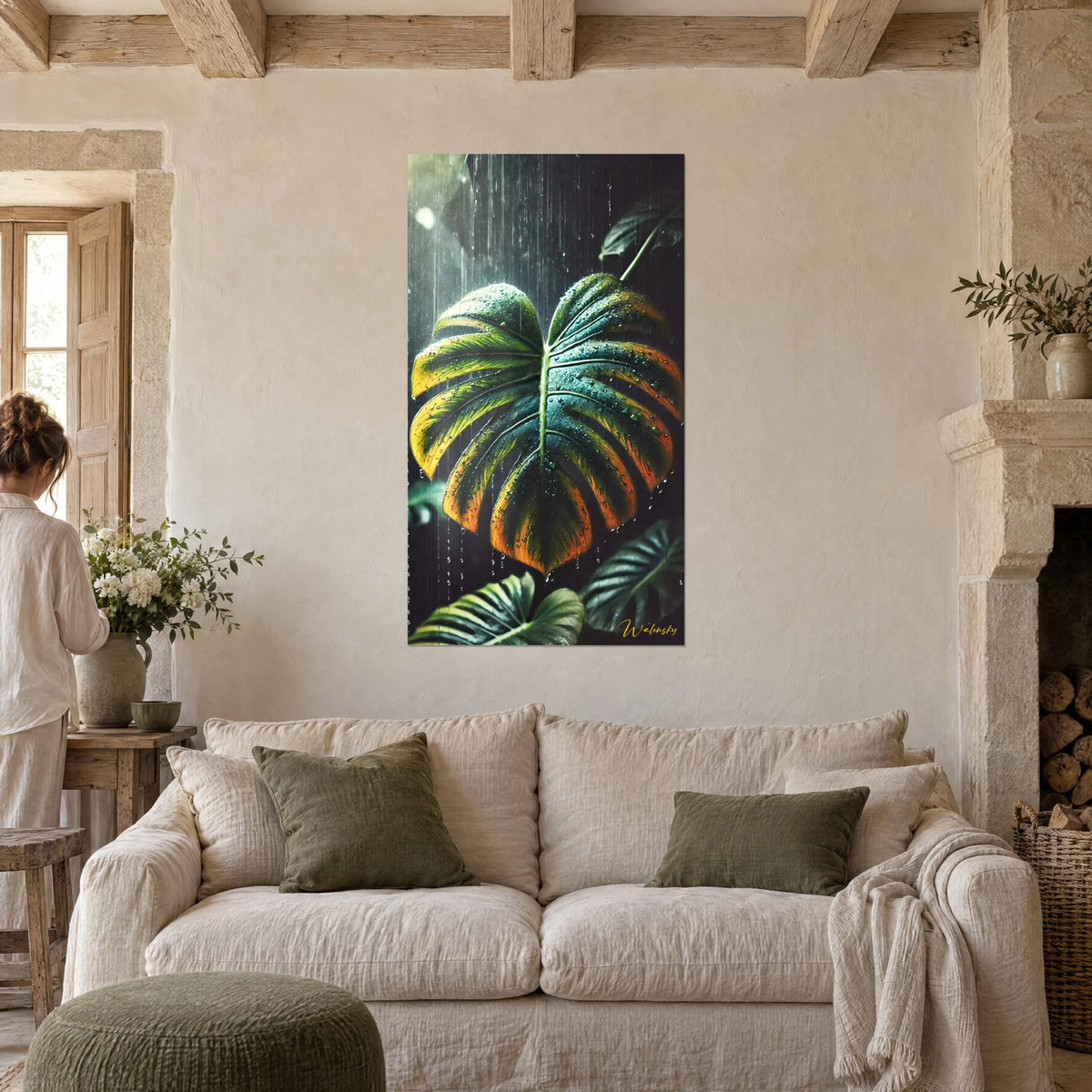 Gemälde Monstera-Blatt in Grün und Orange im Regen, perlende Tropfen, mit einer Frau von hinten, über einem Sofa in einem hellen Wohnzimmer