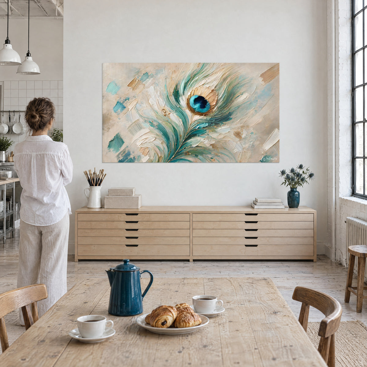 Obraz piórka w turkusie i jasnym złocie na beżowym tle, centralne kobaltowe oko, zawieszony nad drewnianą komodą