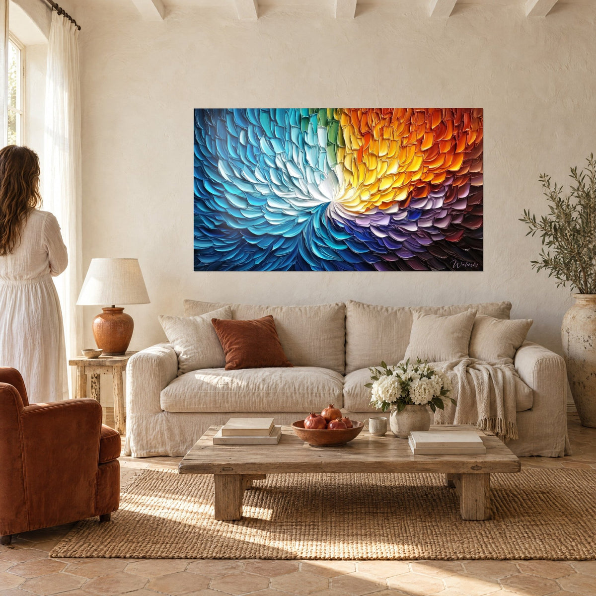 Wall art with a spiral of turquoise blue and fiery orange feathers, hanging above a sofa in a bright living room