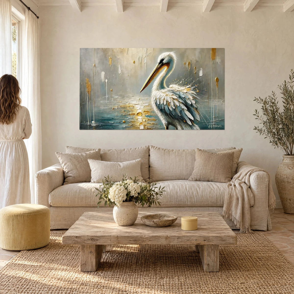 Gemälde eines weißen Pelikans mit langem goldenem Schnabel, blaugraue Federn auf silbernem Grund, über einem Sofa in einem hellen Wohnzimmer