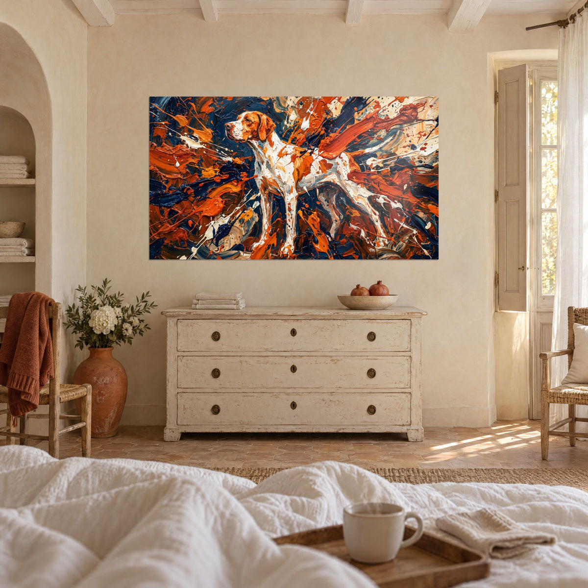 Cuadro braco con manchas naranja quemado, empastes crema y azul noche, frente a una sábana blanca, encima de una cama en un dormitorio luminoso