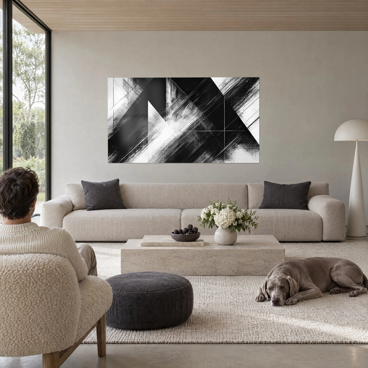 Tableau triangles noirs et blancs aux stries de pinceau, réunis en pointes, au-dessus d'un canapé dans un salon lumineux
