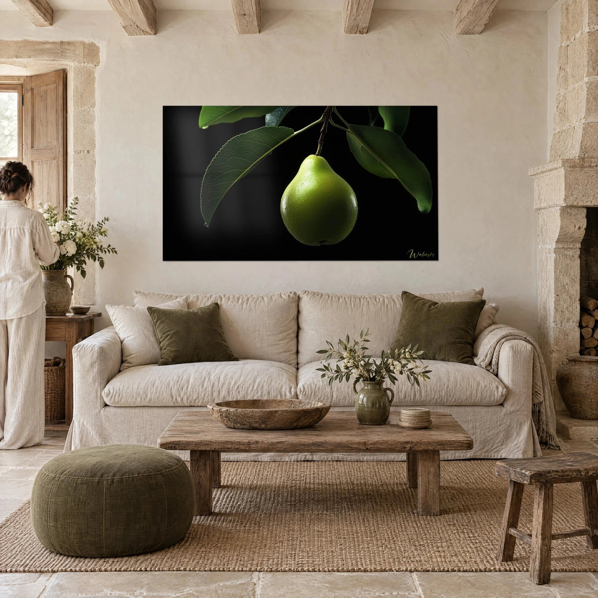 Quadro pera verde perlata di gocce, sospesa su fondo nero, foglie verde scuro, una donna di spalle, sopra un divano in un soggiorno luminoso