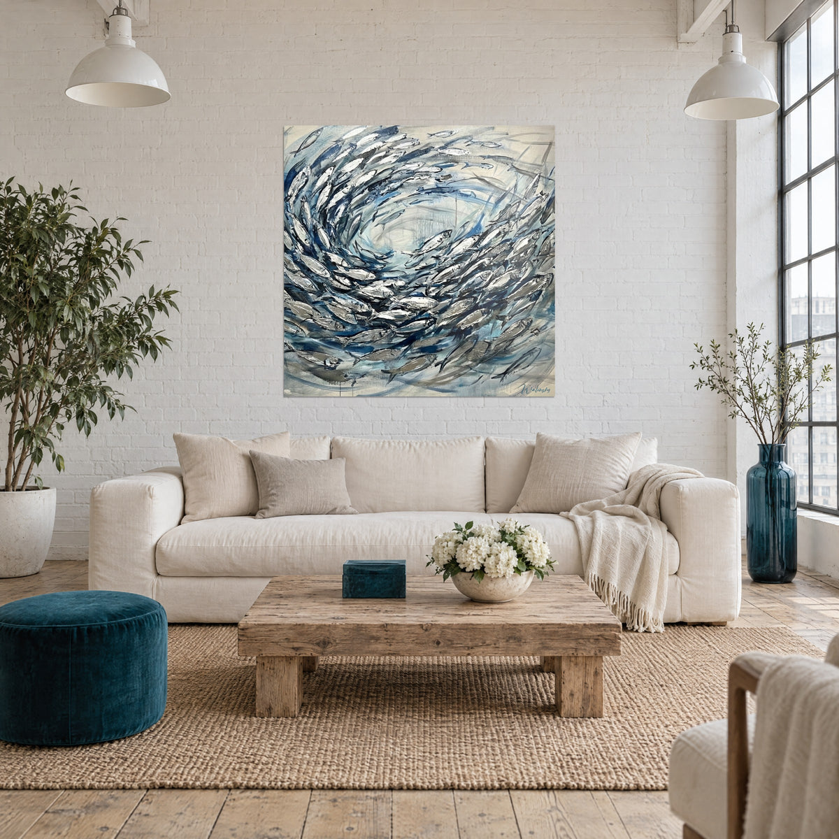Tableau banc de sardines argentées en spirale, bleu marine et blanc nacré, coups de couteau, au-dessus d'un canapé dans un salon lumineux