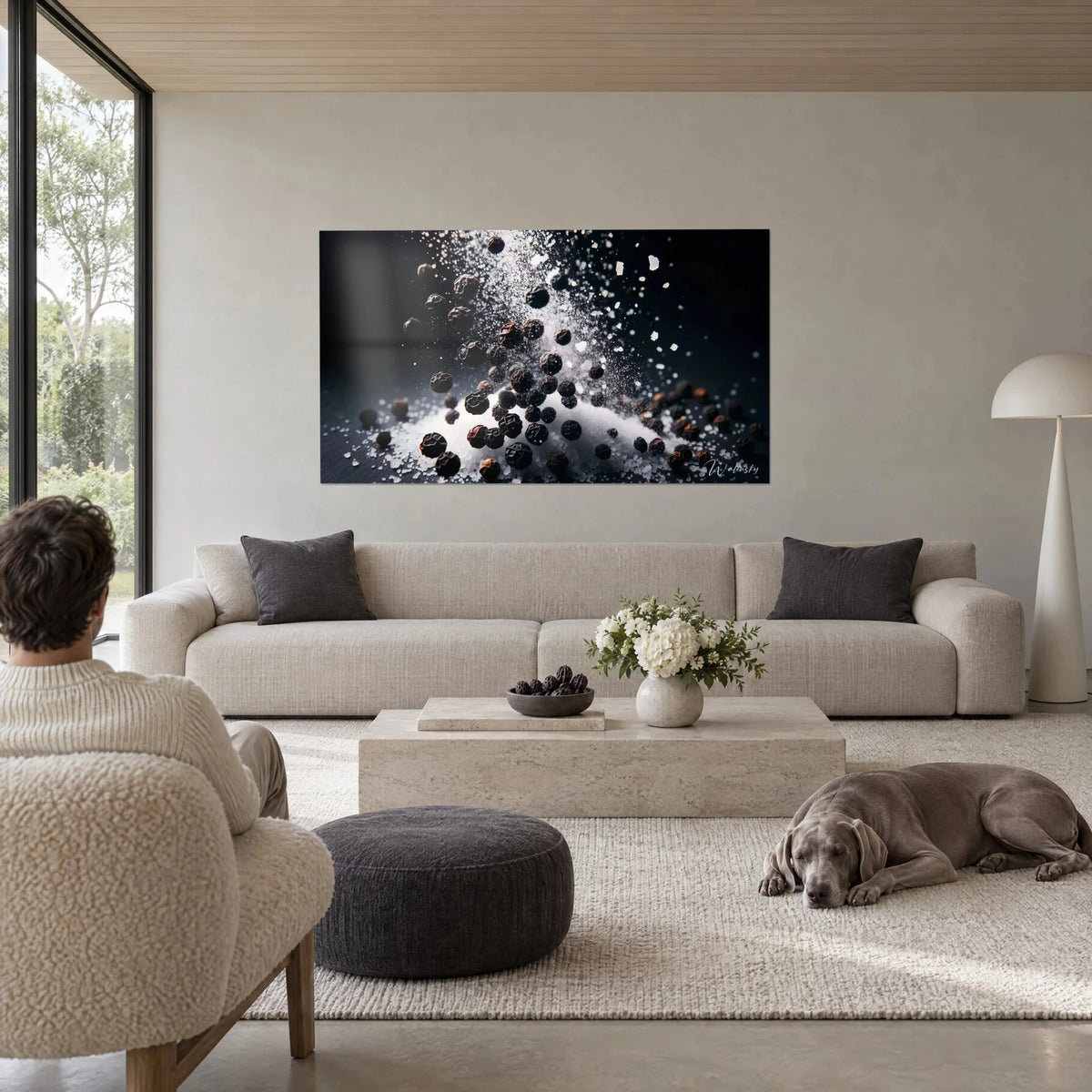 Tableau grains de poivre noir en suspension dans une pluie de sel blanc, fond d'encre, au-dessus d'un canapé dans un salon lumineux