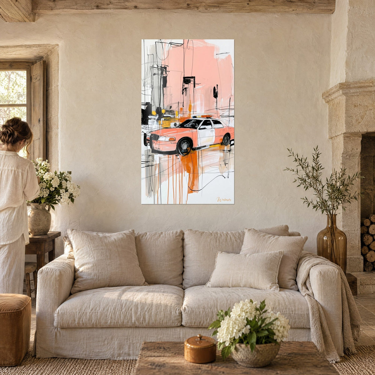 Wall art coral police car with orange drips, bold black sketched lines, a woman seen from behind, hung above a sofa in a bright living room