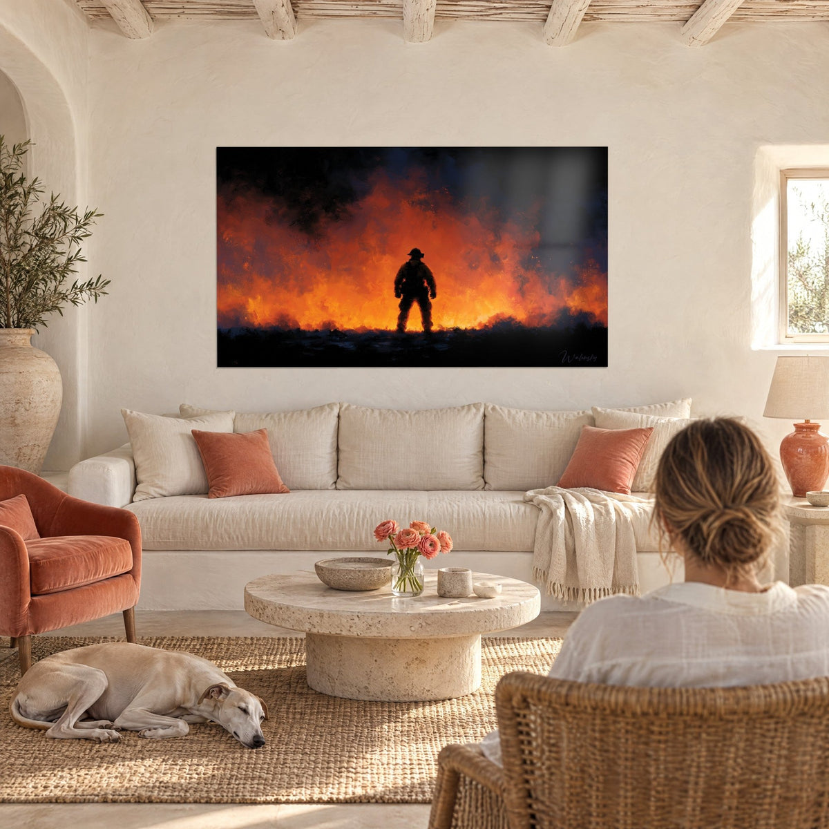 Tableau pompier en silhouette noire face à un mur de flammes orange, ciel bleu nuit, au-dessus d'un canapé dans un salon lumineux