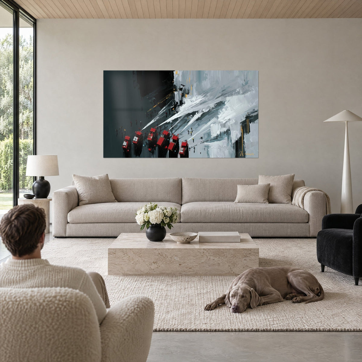 Tableau camions rouges en file, jets d'eau blancs sur un mur gris-bleu, deux personnes de dos, au-dessus d'un canapé dans un salon lumineux