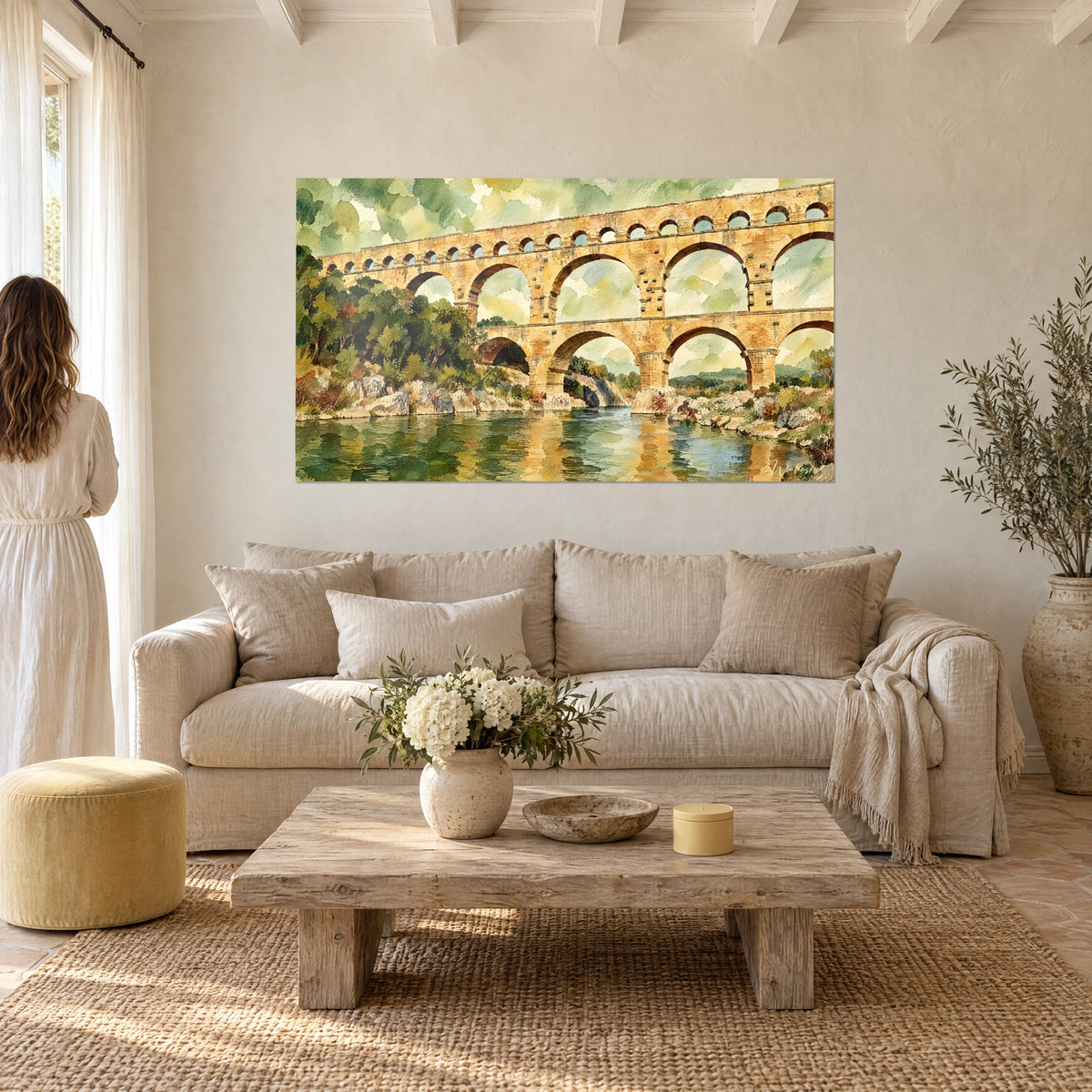 Gemälde Römischer Aquädukt in Gold mit ockerfarbenen Steinbögen und grünem Laub, zwei Personen von hinten, über einem Sofa in einem hellen Wohnzimmer
