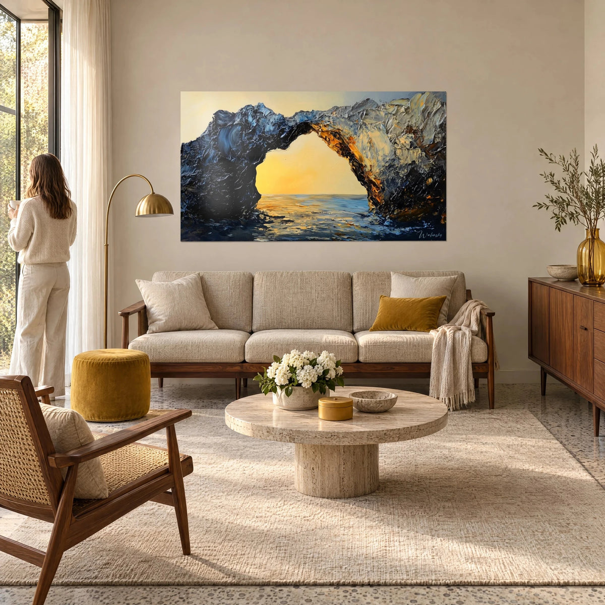 Quadro arco di roccia in pietra nera e azzurrata che si apre su un sole giallo zafferano, mare scintillante, sopra un divano in un soggiorno luminoso