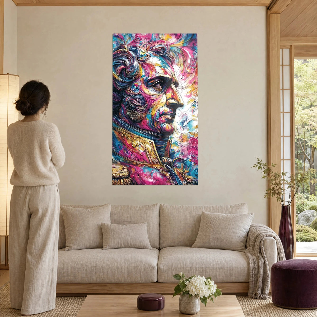 Tableau profil de monarque en peinture tourbillonnante rose et bleu, dorures épaisses, personne de dos, au-dessus d'un canapé dans un salon lumineux