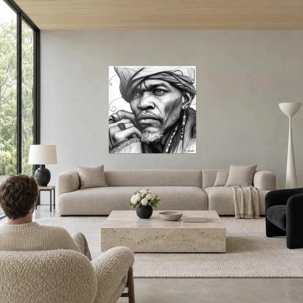 Schilderij gezicht van een man met gekrabbelde tulband, zwarte lijnen op witte achtergrond, hand onder de kin, boven een bank in een lichte woonkamer