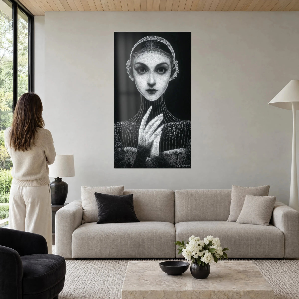 Tableau jeune femme au regard sombre, main aux ongles longs, blanc nacré sur fond noir, au-dessus d'un canapé dans un salon lumineux
