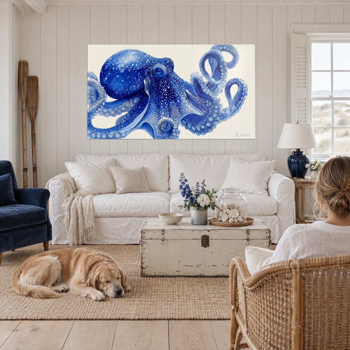 Gemälde Krake in Indigo mit spiralförmigen Armen und weißen, gesprenkelten Saugnäpfen, über einem Sofa in einem hellen Wohnzimmer