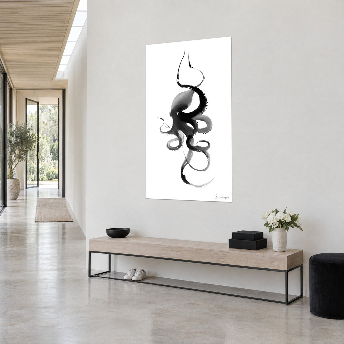 Wall art brush-drawn cephalopod, charcoal head shaded in grey on a white background, three-quarter view in a bright hallway