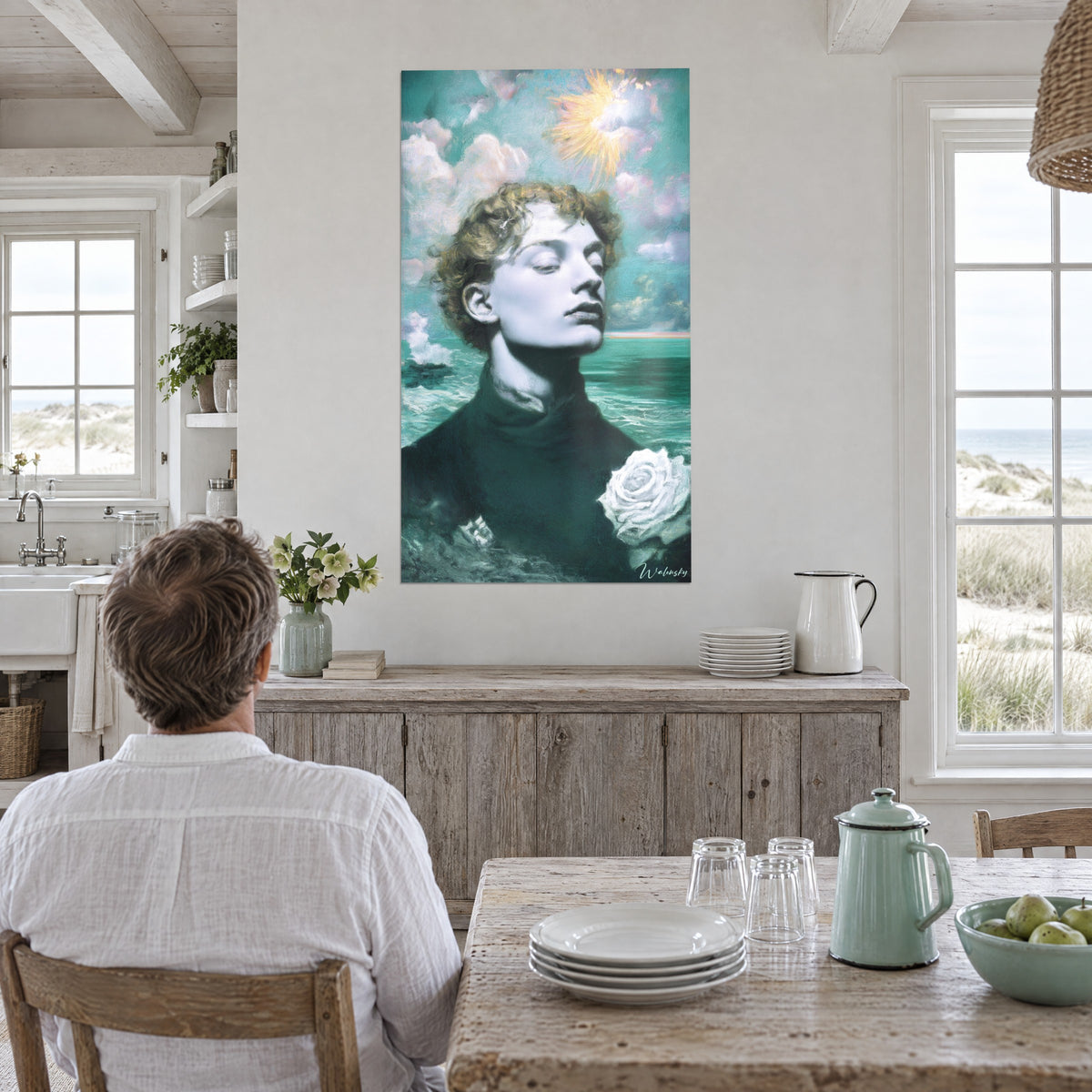 Cuadro figura de cabello rizado, sol amarillo radiante y olas verde agua, pared blanca de una cocina abierta a las dunas