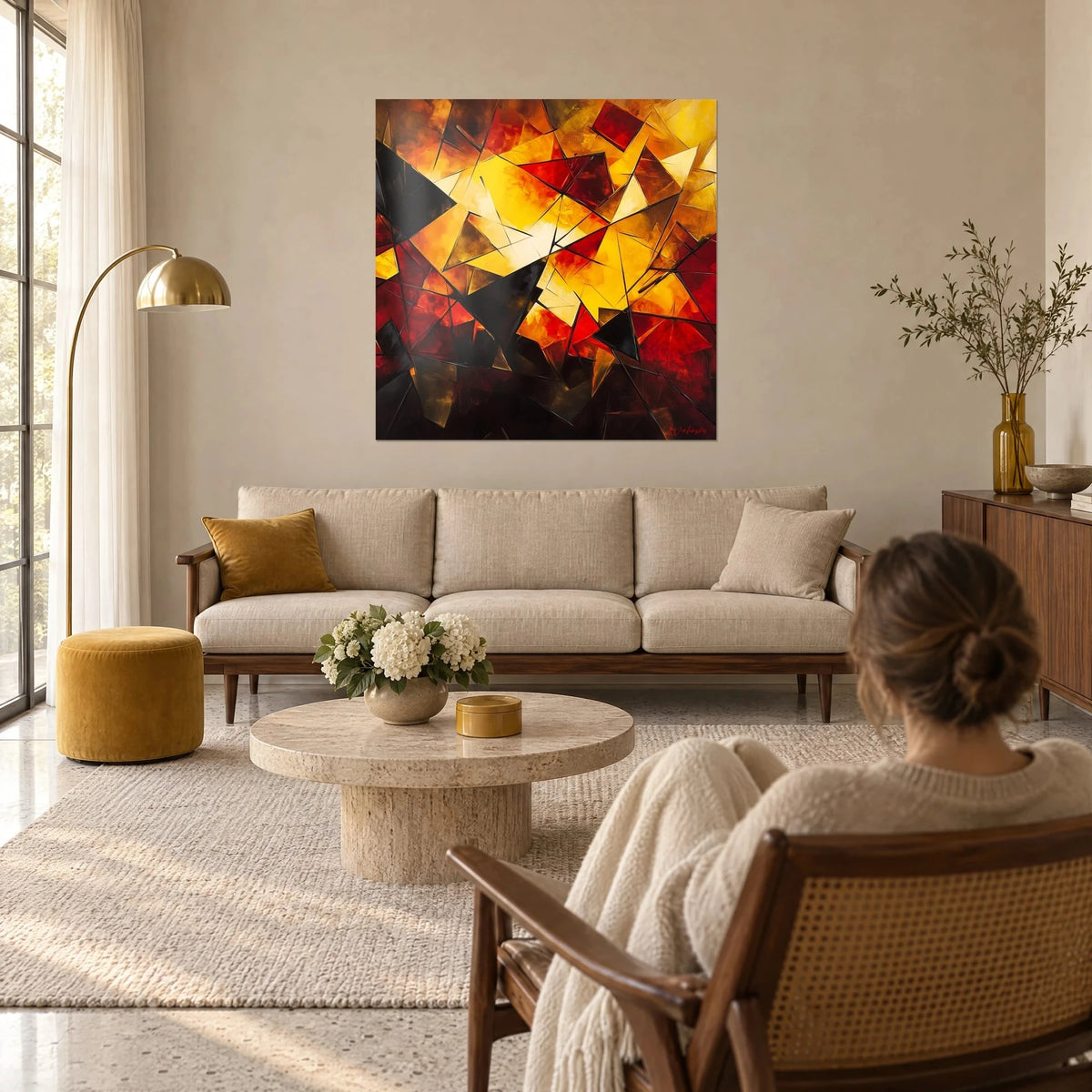 Tableau triangles éclatés jaune soleil et rouge sang, arêtes noires fines, accroché au-dessus d'un canapé dans un salon lumineux