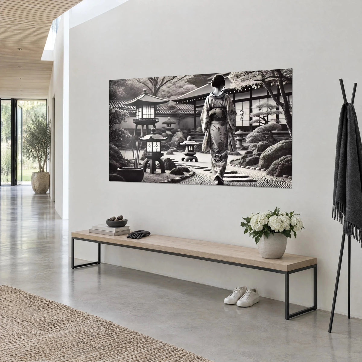 Quadro geisha di spalle lungo un giardino zen, kimono floreale color crema e nero, lastre di pietra scura, vista di tre quarti in un soggiorno d'architetto