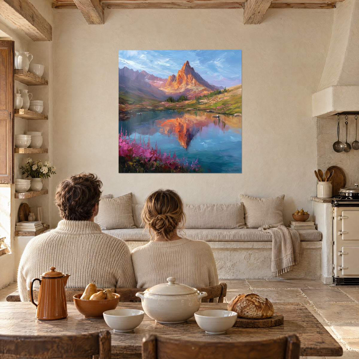 Gemälde eines aprikosenfarbenen Alpengrats unter azurblauem Himmel, Spiegelsee und fuchsiafarbene Blüten, zwei Personen von hinten am Tisch in einer Steinküche