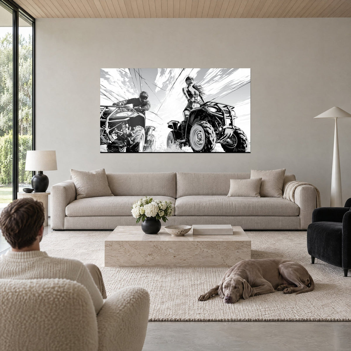 Wall art quad biker wearing a black and white helmet, young woman standing in glasses, streaked sky, above a sofa in a bright living room