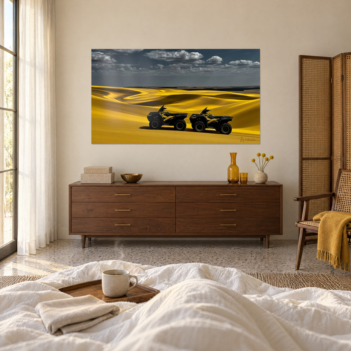 Wall art pair of anthracite four-wheelers striped in bright yellow, amber dunes and grey cloud wisps, above a bed in a light bedroom