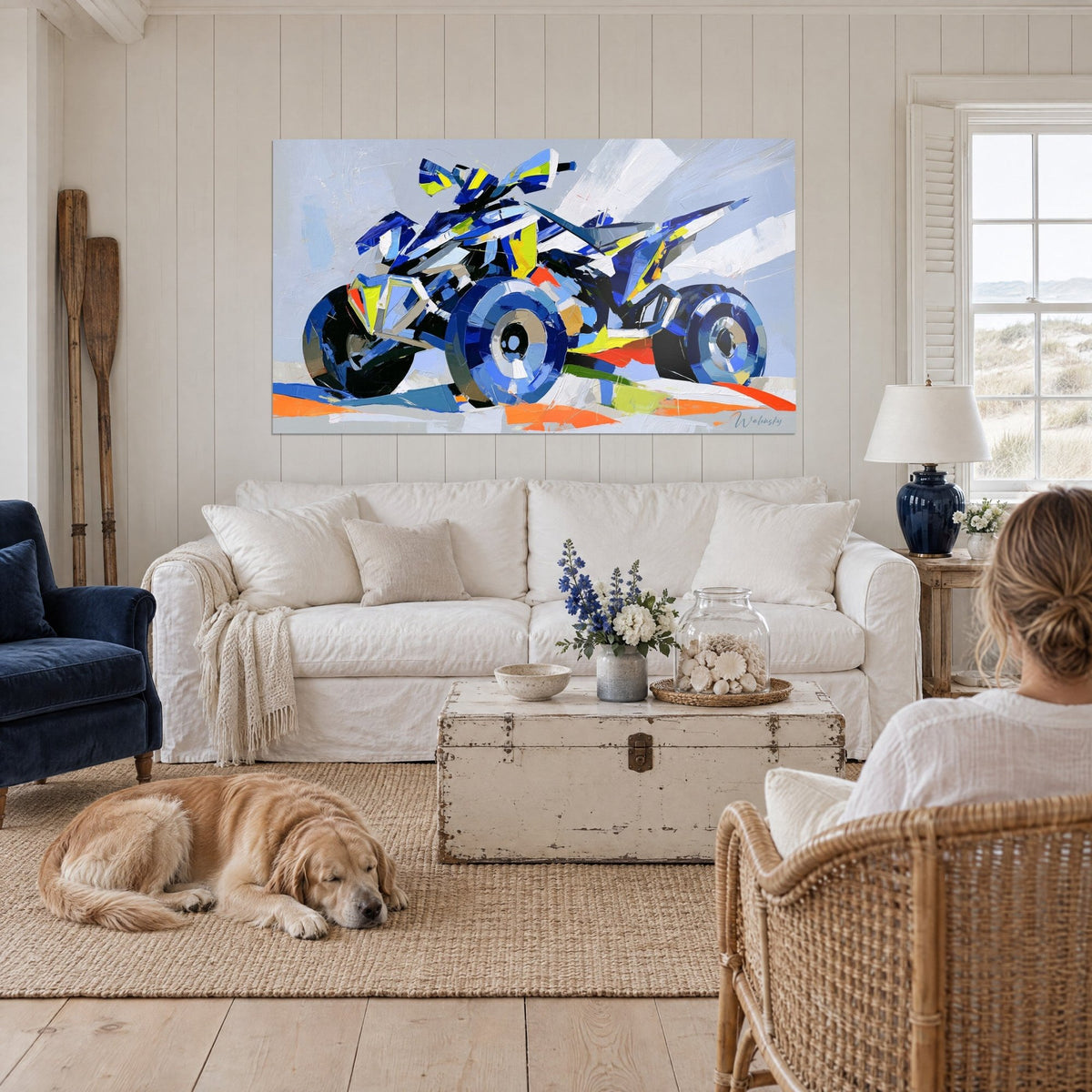 Wall art quad with cobalt blue wheels striped in lemon yellow, orange line beneath the chassis, hanging above a sofa in a bright living room