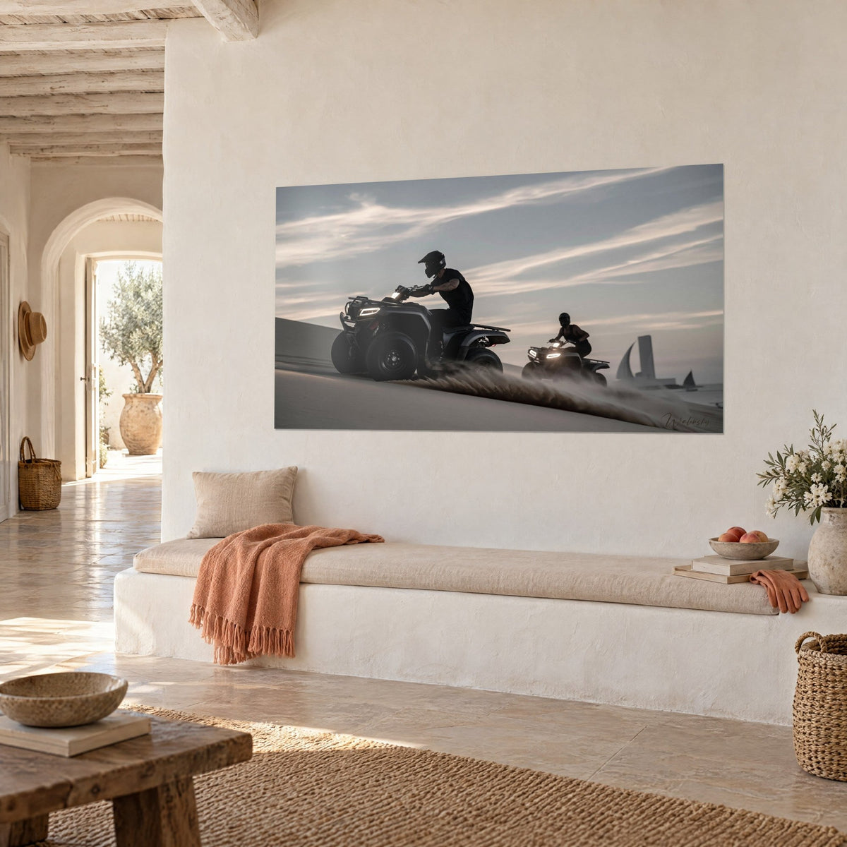 Wall art of a helmeted rider on his anthracite quad, golden sand kicked up in a spray, two sailboats in the distance, cream wall of a Mediterranean house