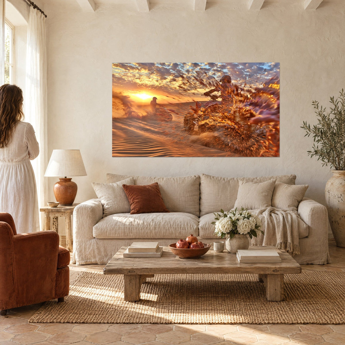 Tableau quad lancé dans une gerbe de sable ambré, ciel d'or et de bleu, accroché au-dessus d'un canapé dans un salon lumineux