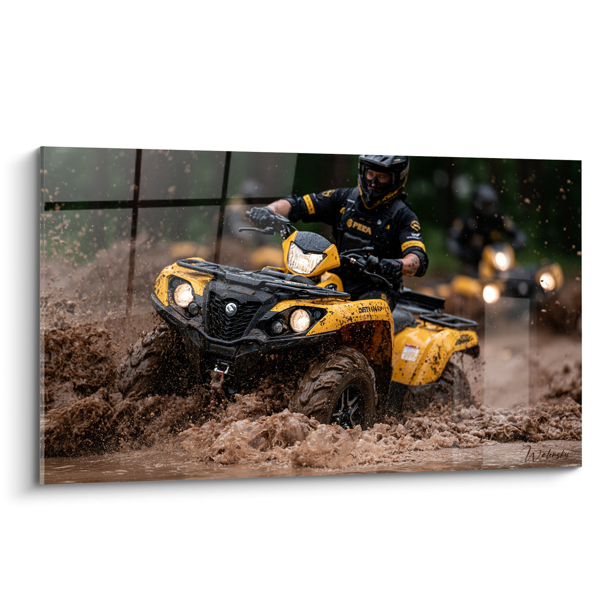 Quad jaune et noir traversant une flaque boueuse marron avec projections d'eau intenses