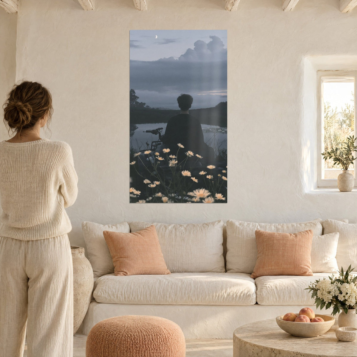 Wall art young man seen from behind by a pond, cream daisies, grey-blue sky and crescent moon, above a sofa in a bright living room