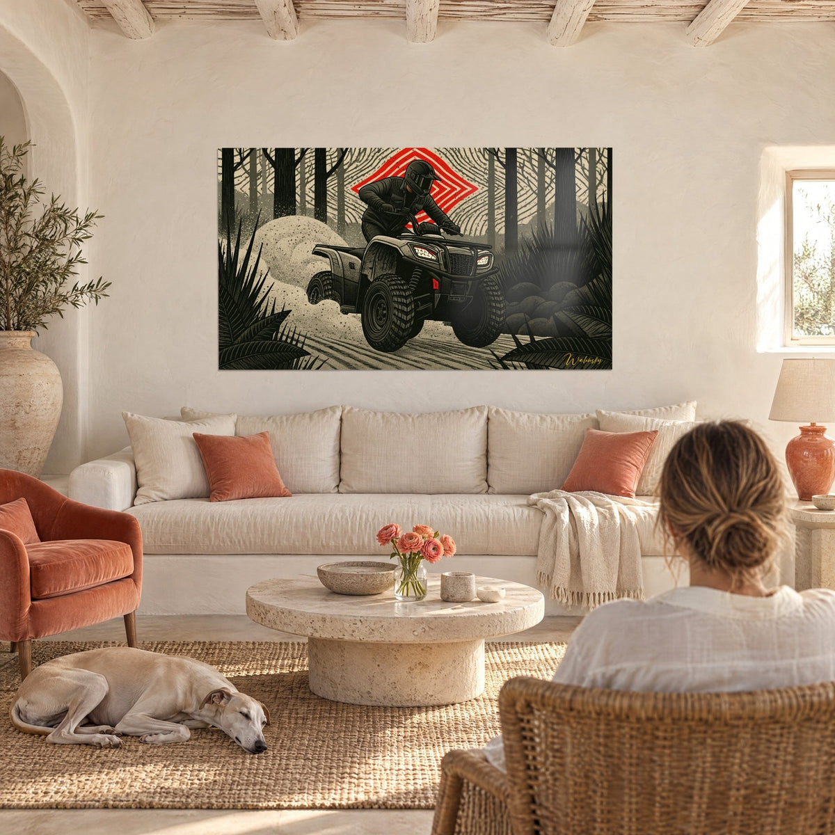 Wall art helmeted quad rider balancing on a black quad, red diamond behind, above a sofa in a bright living room