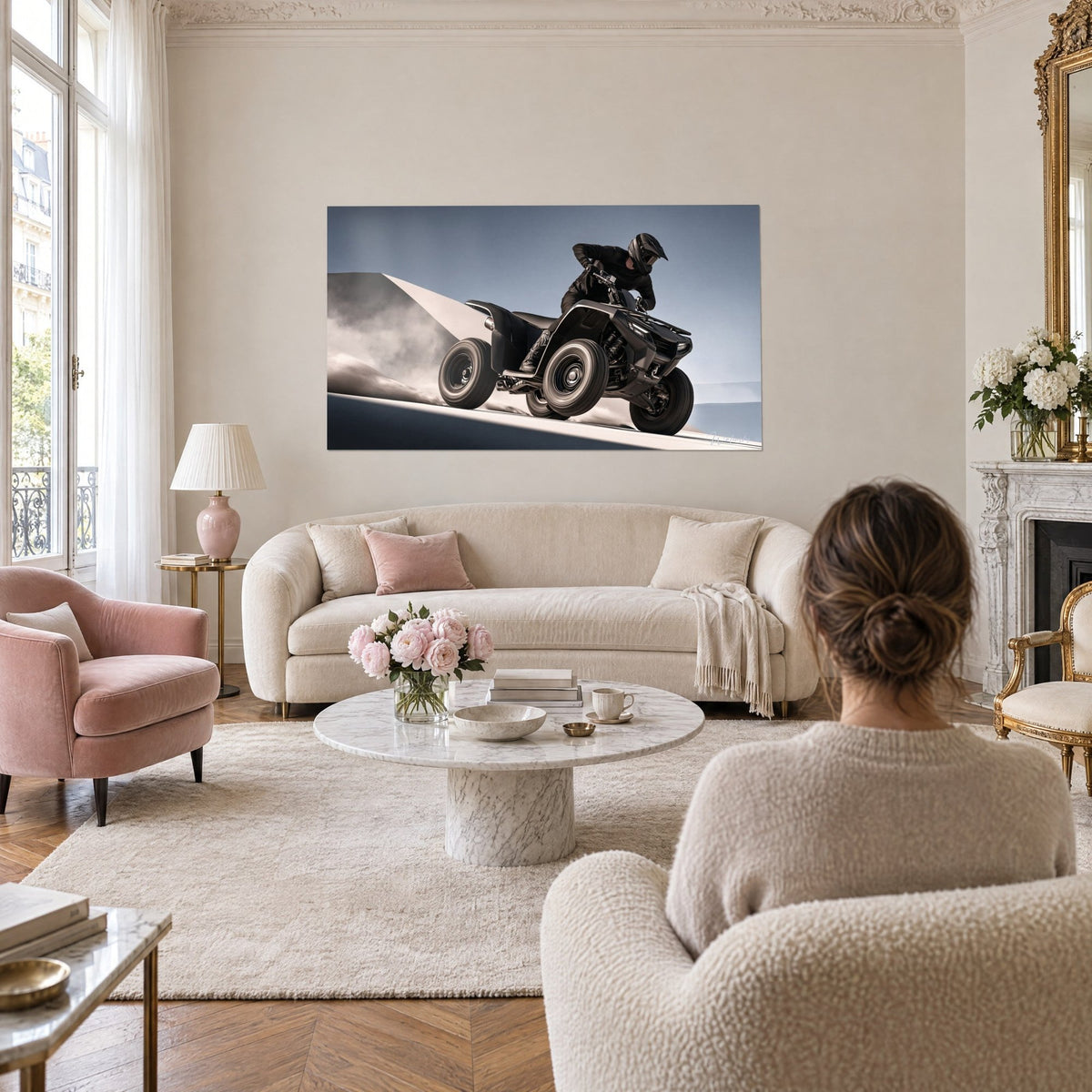 Wall art black quad bike rearing up through beige dust, steel-blue sky, helmeted rider leaning forward, above a sofa in a bright living room
