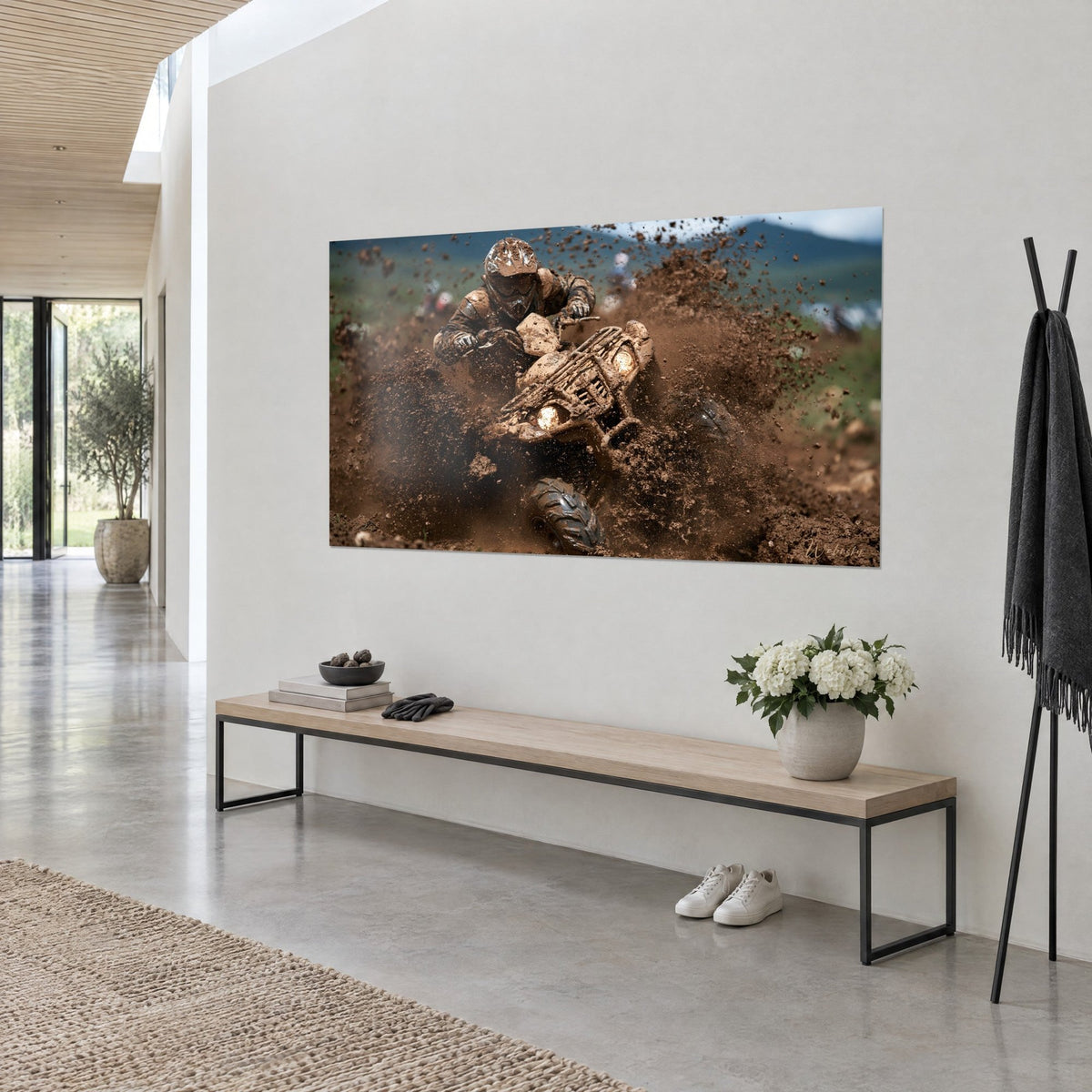 Tableau pilote de quad cuirassé de boue, gerbes marron et crème, montagne bleutée au fond, mur blanc et banc en bois clair
