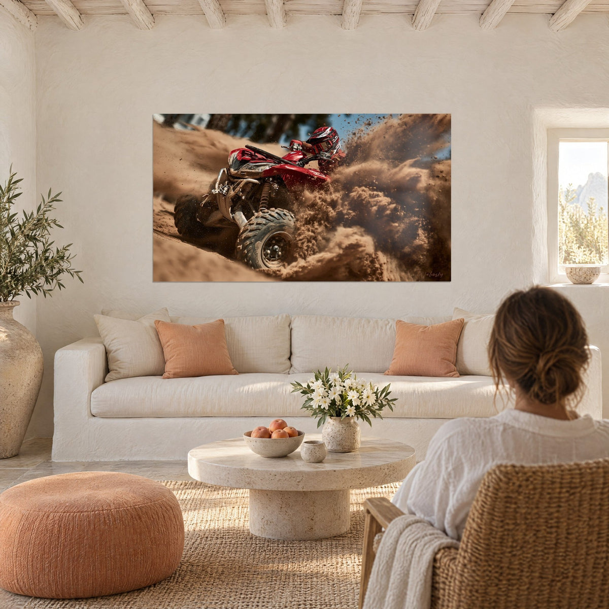 Gemälde roter Quad, der sich in einer Wolke ockerfarbenen Sandes aufbäumt, behelmter Fahrer nach vorn gebeugt, über einem Sofa in einem hellen Wohnzimmer