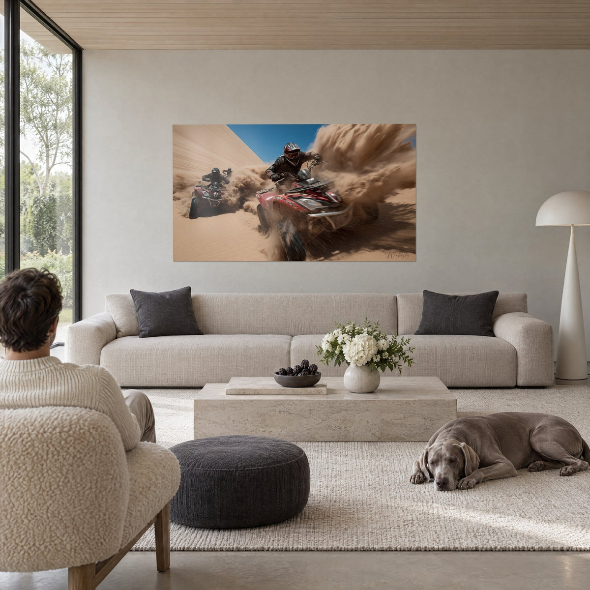 Wall art red quad bike rearing up in golden sand, intense blue sky, plume of dust, above a sofa in a bright living room