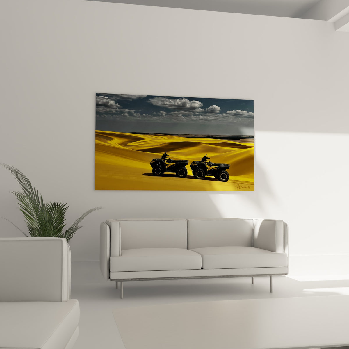 Engins tout-terrain noirs sur sable doré ondulé, au-dessus d'un canapé dans un salon lumineux