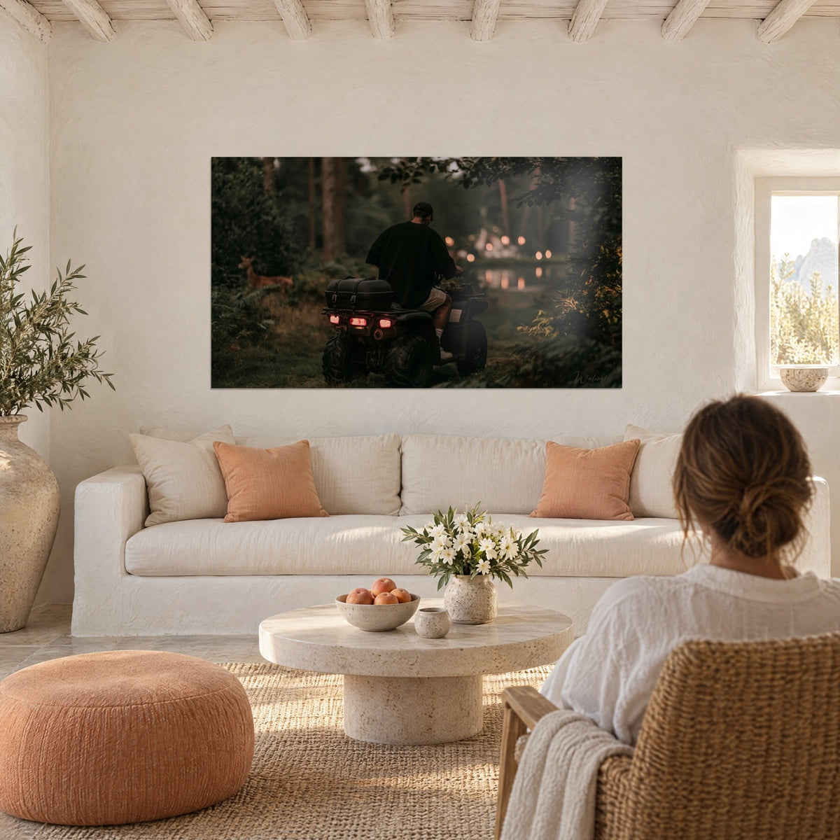 Wall art quad rider seen from behind with red taillights, ochre doe at the forest edge, dark green pond, above a sofa in a bright living room