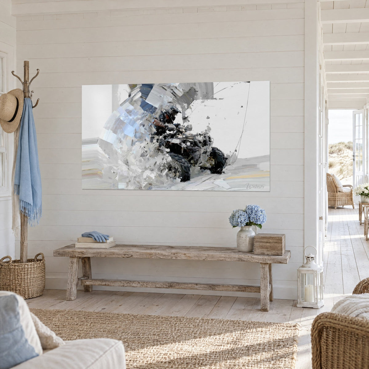 Wall art of an off-road snowmobile with black knobby tyres and white and blue spray, shown three-quarter view in a seaside house