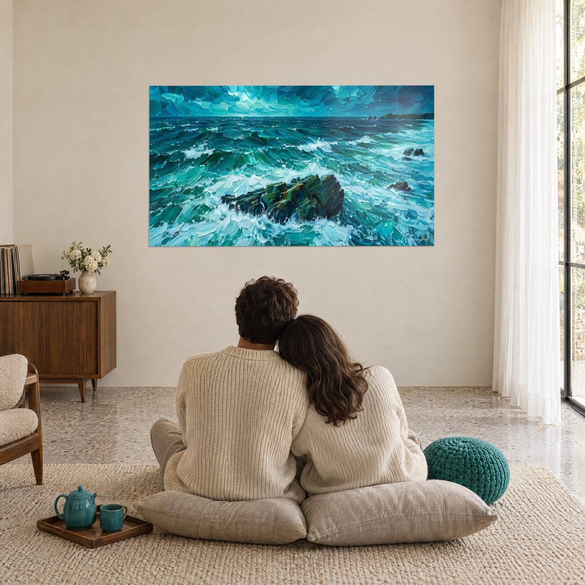 Tableau mer agitée aux coups de spatule bleu glacier et vert sapin, rocher au centre, contemplé par un couple assis sur des coussins