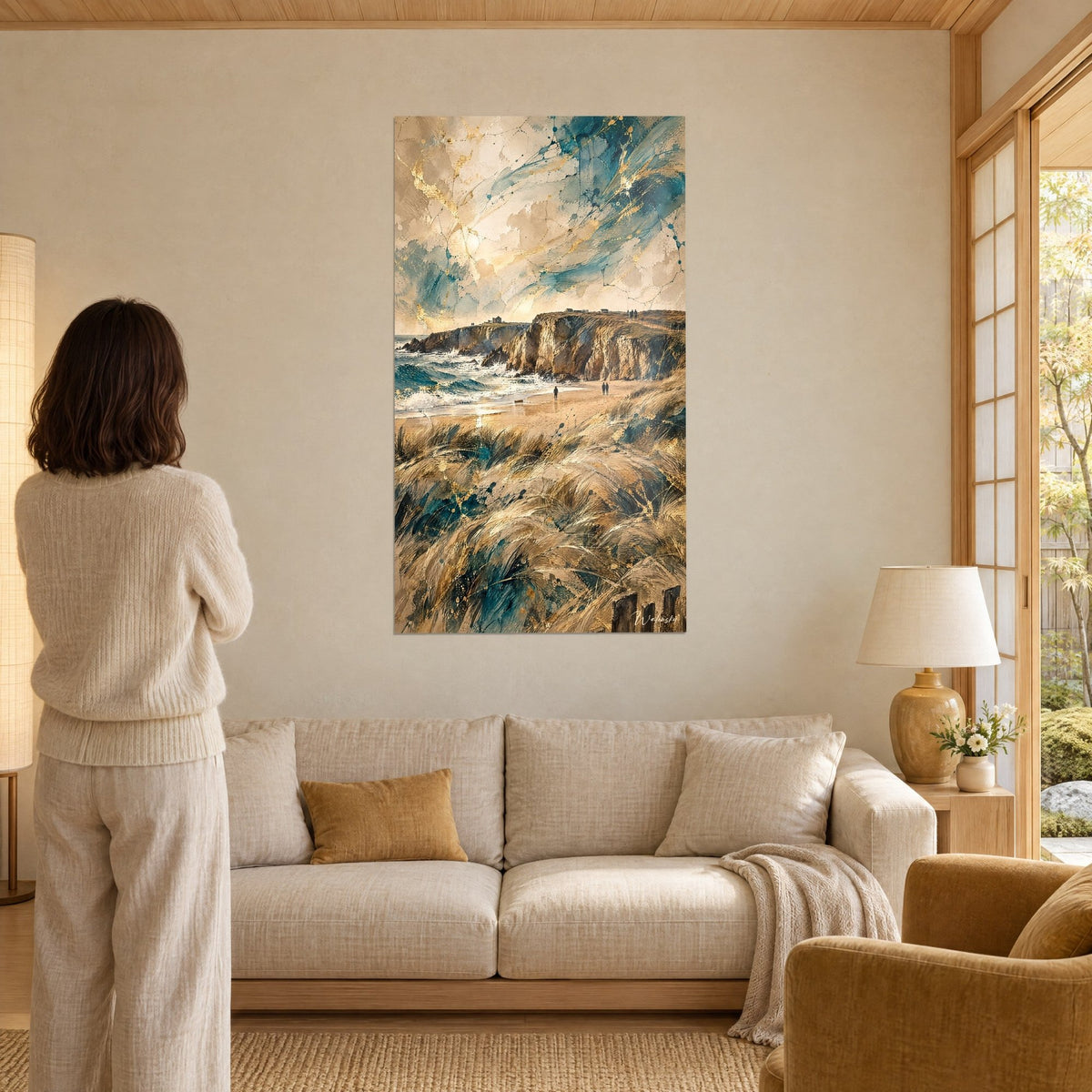 Πίνακας βραχώδη ακτή του Κιμπερόν κάτω από έναν πετρελαιοπράσινο ουρανό με χρυσές φλέβες, γυναίκα από την πλάτη, πάνω από καναπέ σε φωτεινό σαλόνι