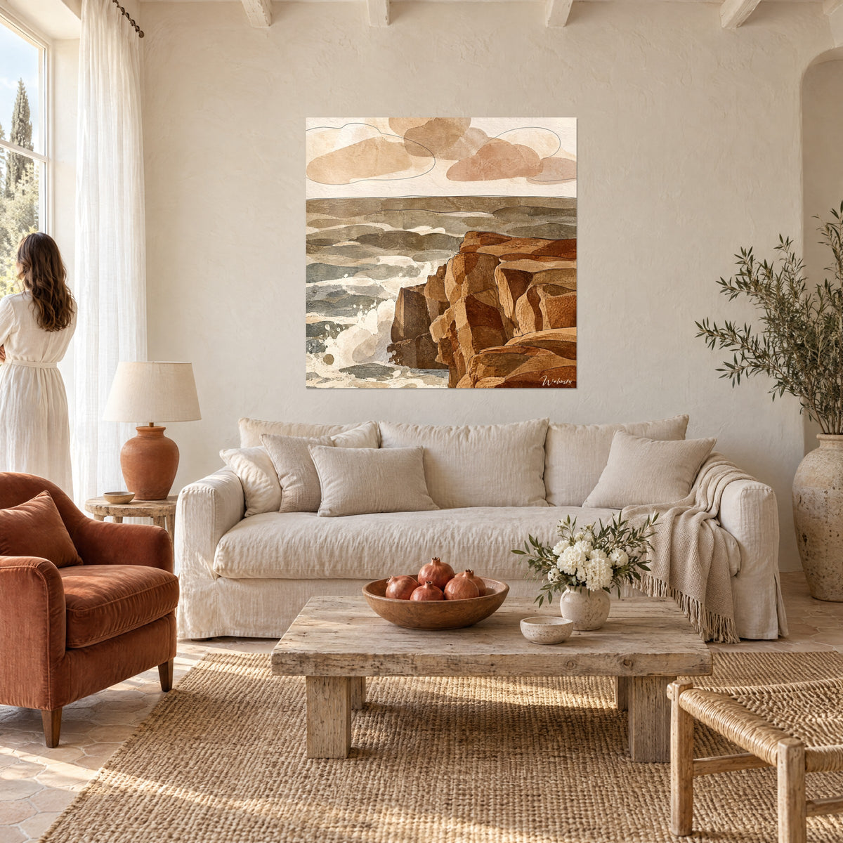 Tableau falaise ocre aux strates rouille face aux vagues grises, nuages beige rosé, au-dessus d'un canapé dans un salon lumineux